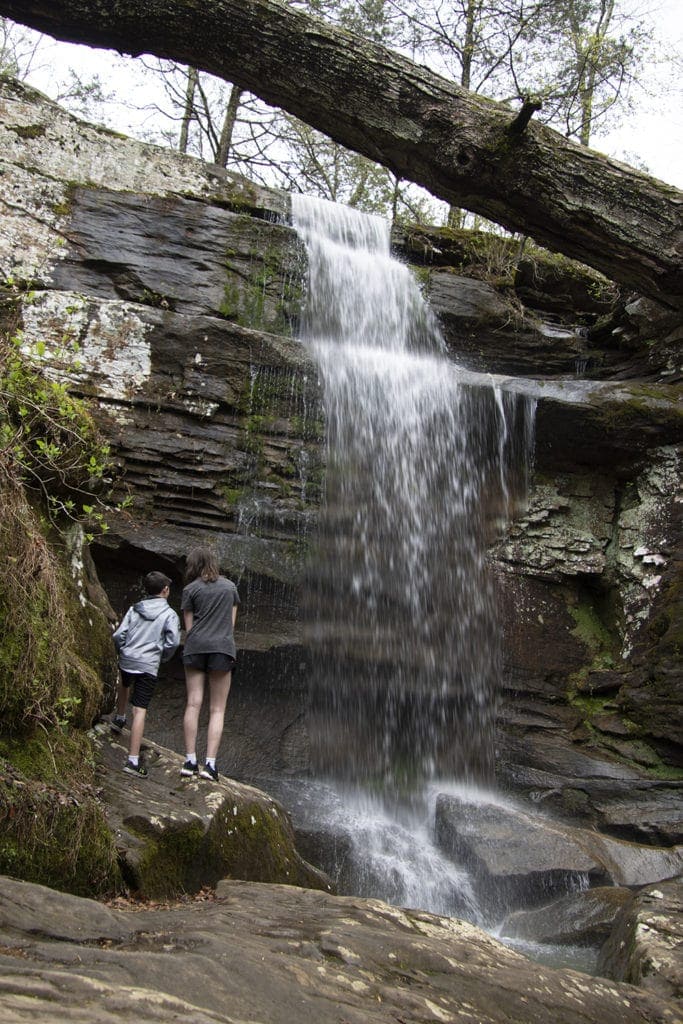 Two kids standing in front of lower Burden Falls in Shawnee National Forest.