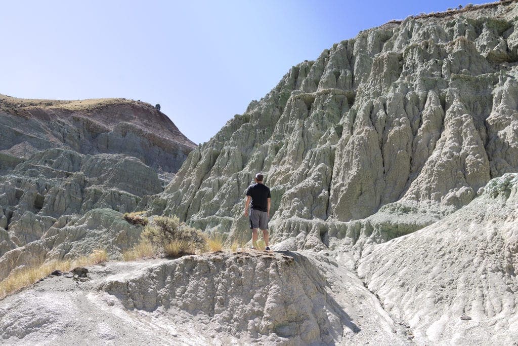 A man standing and looking at the Blue Basin in Oregon. Just hiked Island in Time Trail.