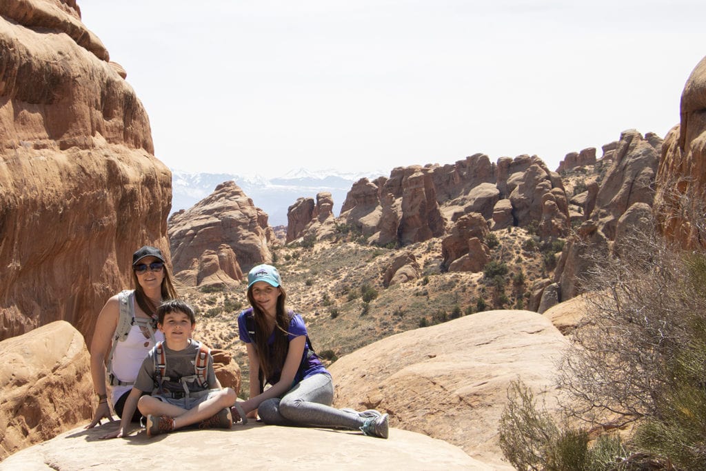 Family stopped for a photo to take in the view on the way to Double O Arch in Arches National Park.