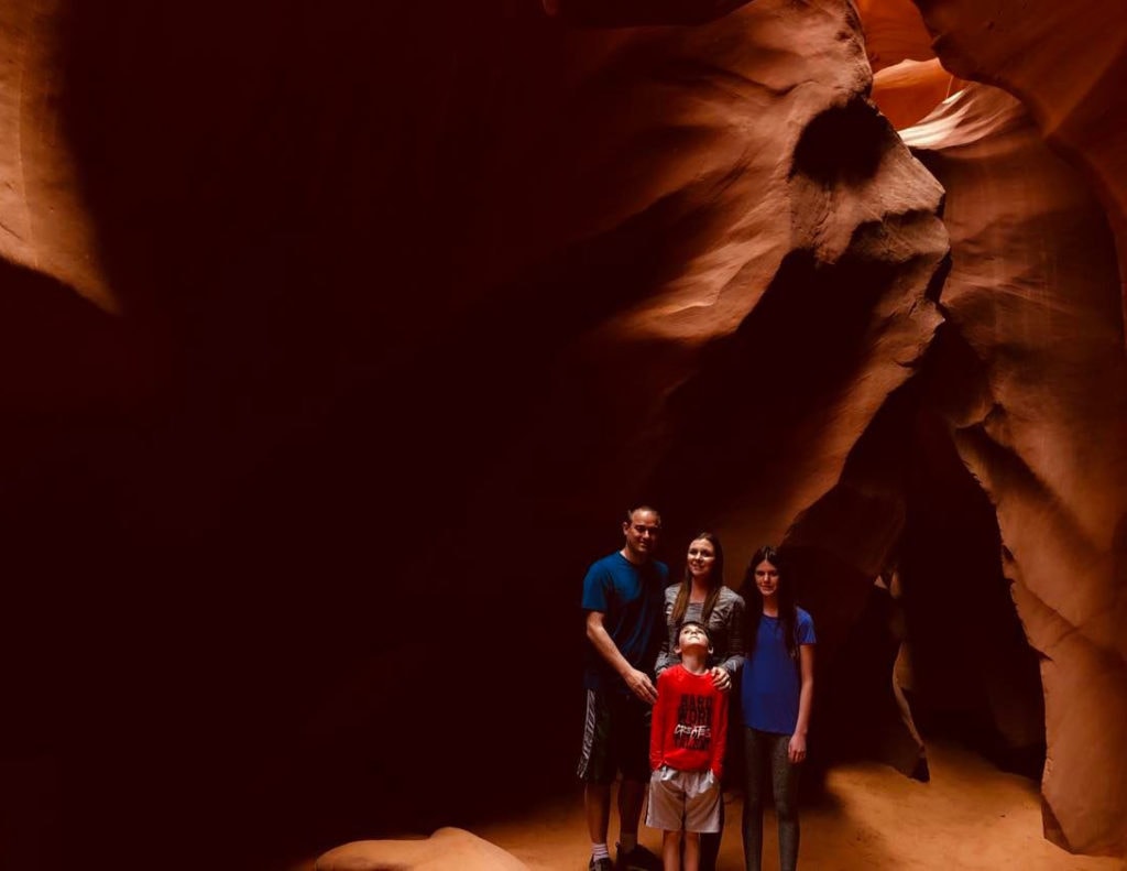 Family exploring Lower Antelope Canyon: a captivating day trip from Zion National Park. Discovering the beauty of slot canyons and natural wonders together.