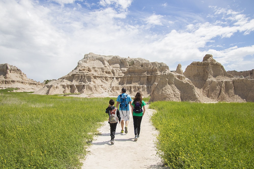 View of hiking trail with Badlands formations in the distance.