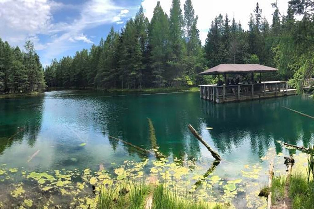 Kitch-iti-kipi. Michigan's largest freshwater spring with emerald green water and a self propelled wooden raft.