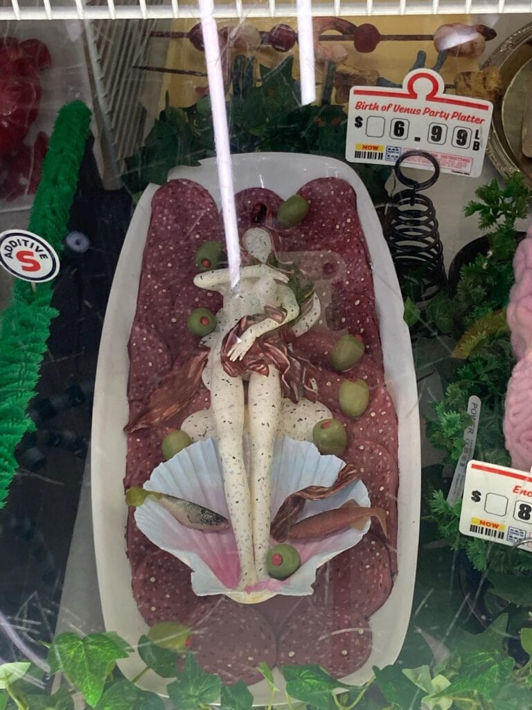 Faux deli meat platter at Omega Mart. Shaped like a person surrounded by anchovies, salami and olives.