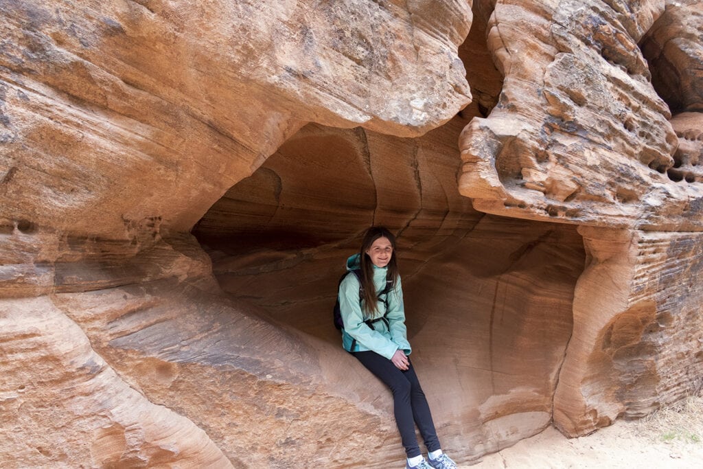 Girl sitting in a small cave at Zion National Park