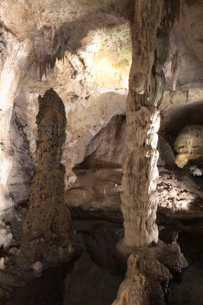 Interior of Carlsbad Caverns, showcasing giant limestone pillars. Illuminated cave formations create a mesmerizing underground landscape in the heart of the park.