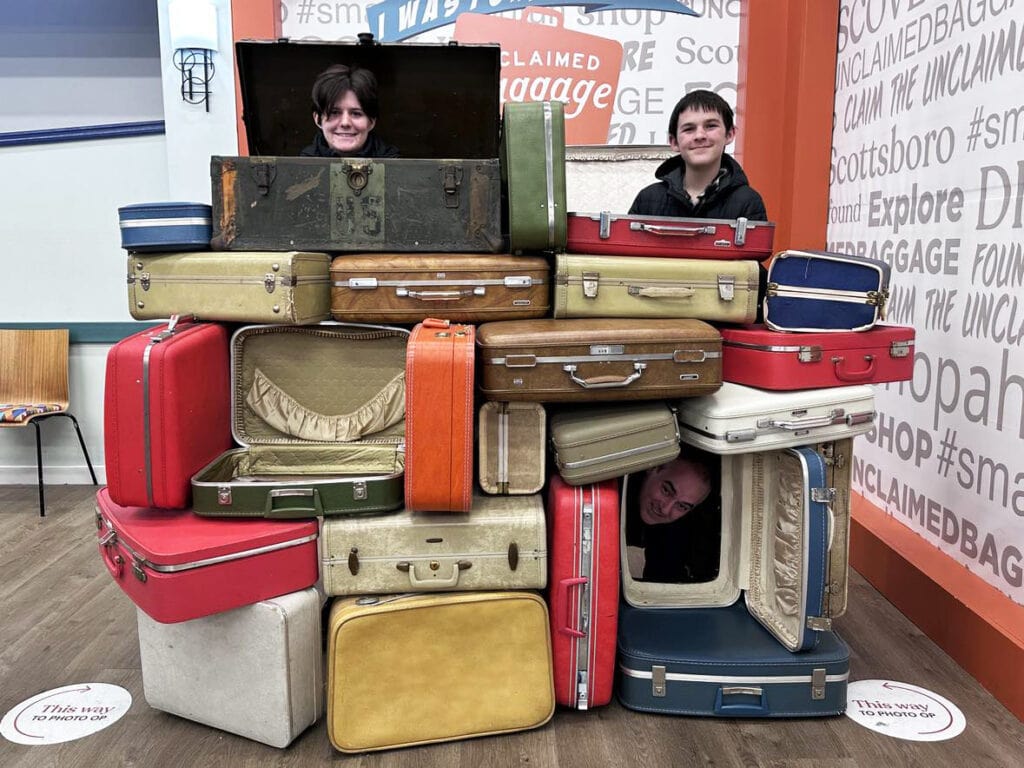 Photo Opportunity at Unclaimed Baggage: Vintage suitcases stacked with peek-through holes for a fun and memorable experience.